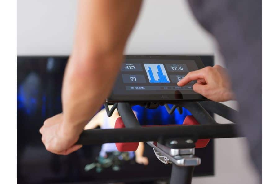Man setting the resistance on a spin bike