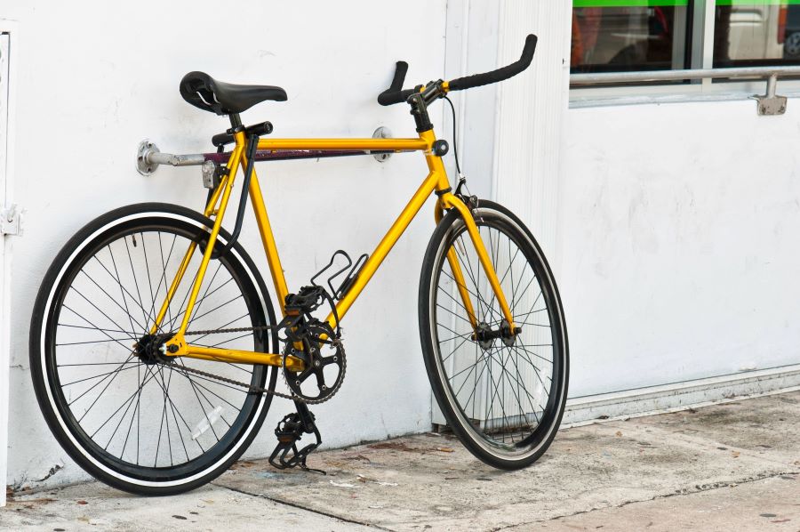 Yellow bike standing by wall