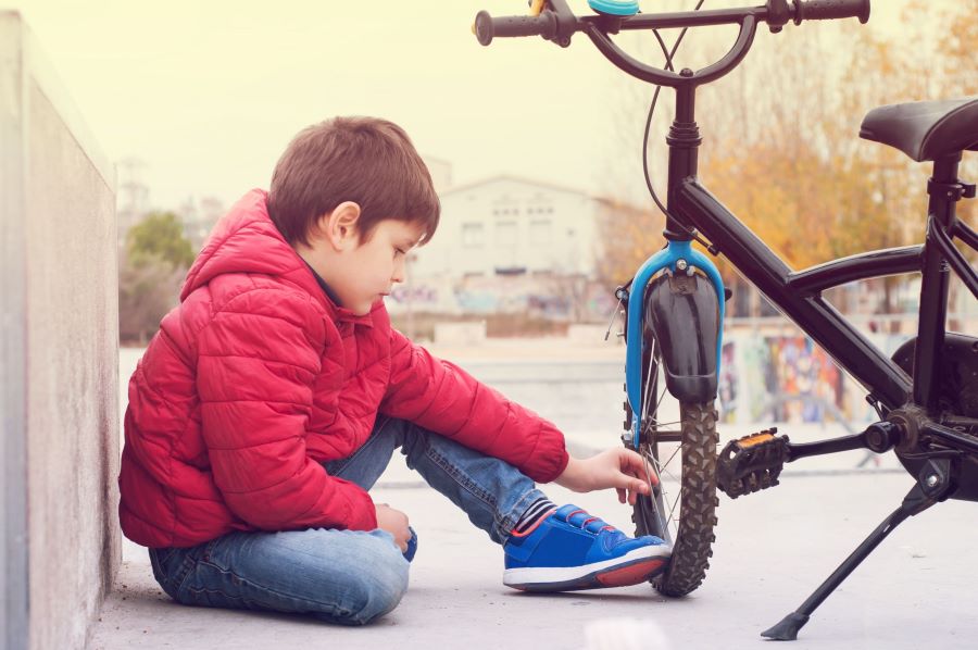 Kid holding his bicycle tire
