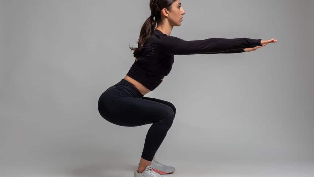 a fitness trainer doing a squat