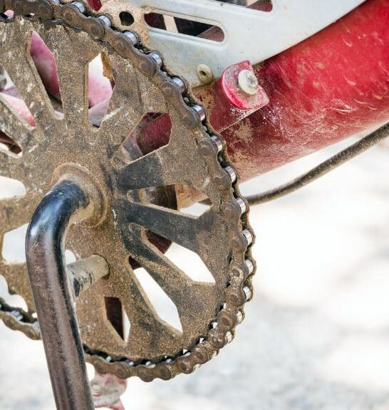 An old, rusted 1x chainring on a red bike