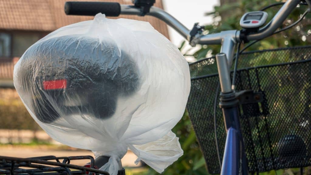 A plastic bag over a leather bike saddle that is stored outside 